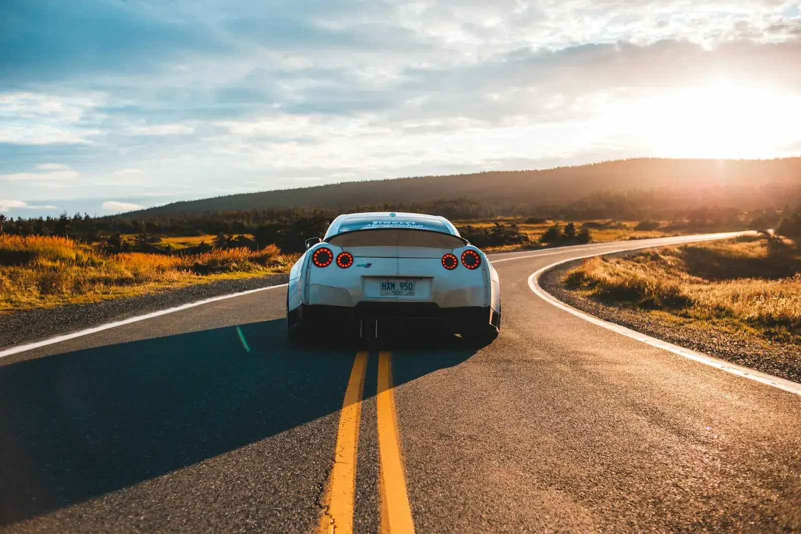 Car on an open road at sunset